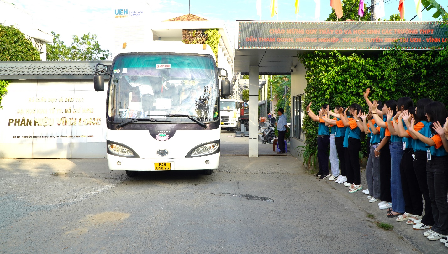 A group of people standing next to a busDescription automatically generated